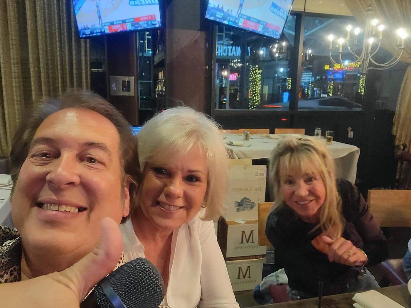 Craig taking a cheerful photo with two friends at a show